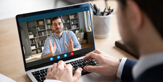 Two men have a video conversation on a laptop