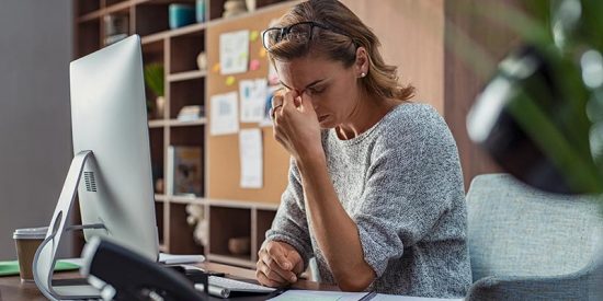 woman stressed at work while on computer