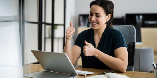 Women employees giving two-thumbs up as feedback to the video call.