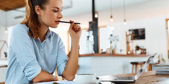 a woman learning attentively while working on laptop