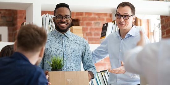 Man enjoying his first day in a new position, unpacking a box of his belongings.