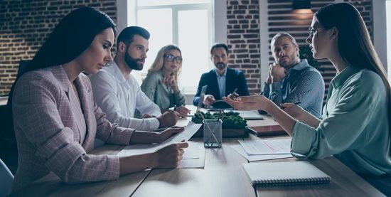 Leaders sit around a table discussing a crisis management plan.