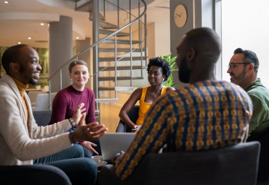 employees conversing around computer