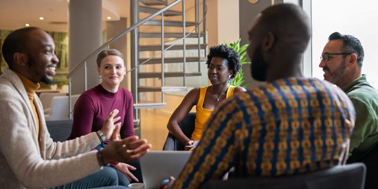 employees conversing around computer