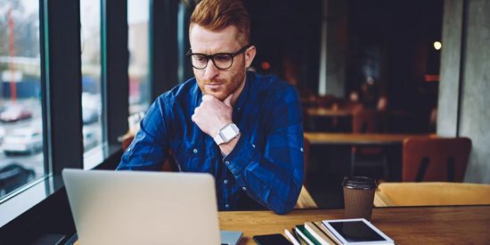 Man sits at computer to complete online training.